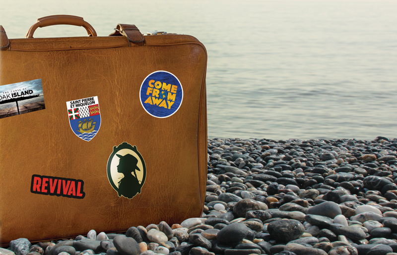 a vintage old tan leather suitcase sits on a pebbly beach by the ocean. There are 'travel stickers' for 'Come From Away', 'Anne of Green Gables', 'St. Pierre', 'Revival', and 'Oak Island'.